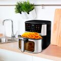 TESLA AirCook Q60 XXL Pro wielofunkcyjna frytkownica na blacie kuchennym, przygotowująca porcję frytek i krążków cebulowych.